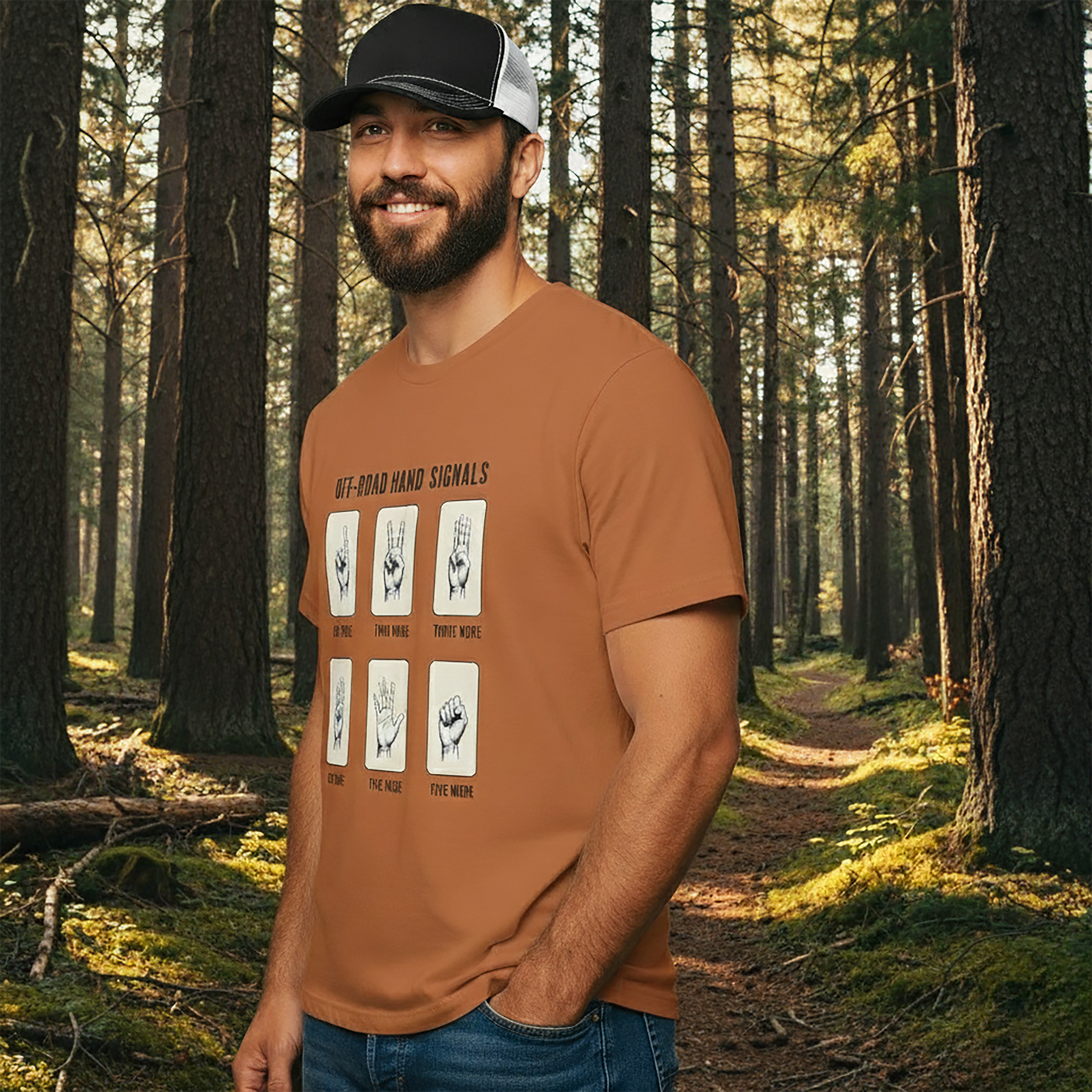 Man wearing a yam color t-shirt with hand signals graphic designs in a forest setting