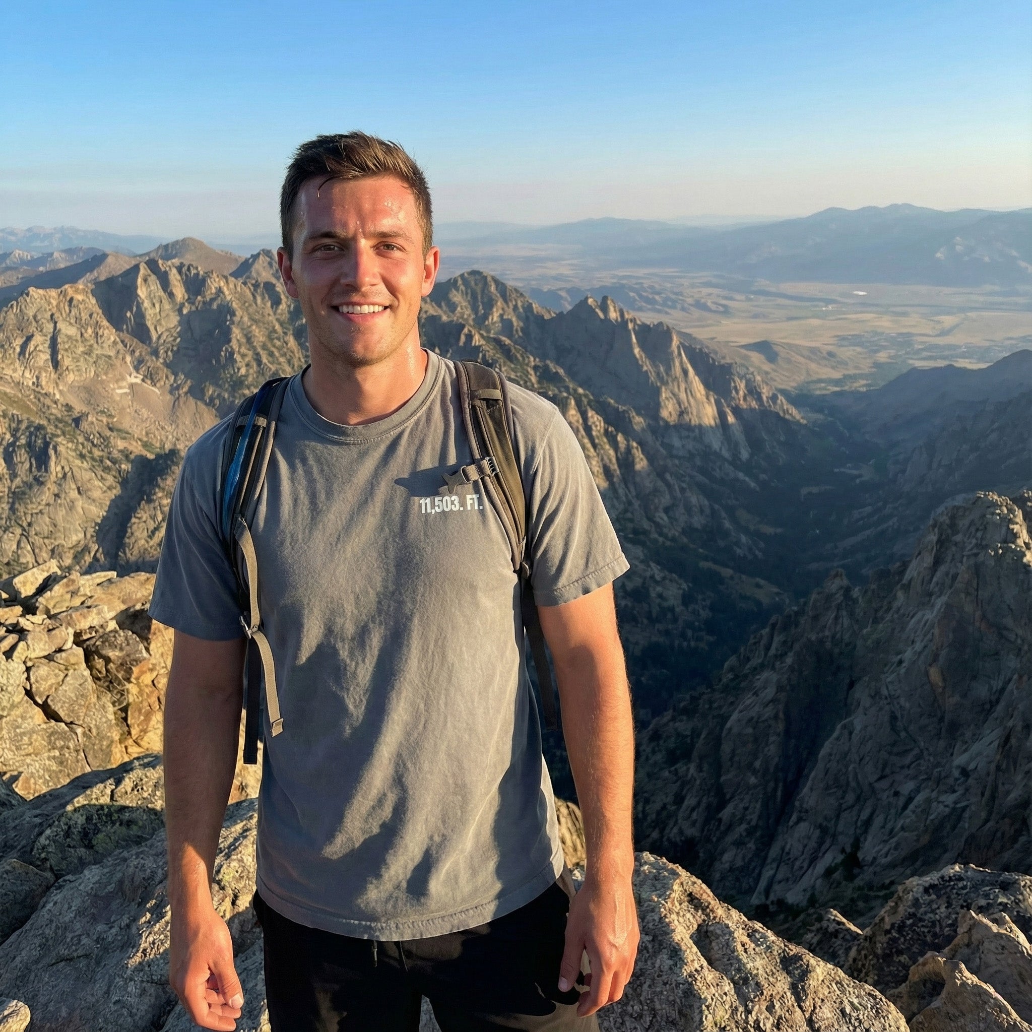 Man standing on a mountain peak with scenic view