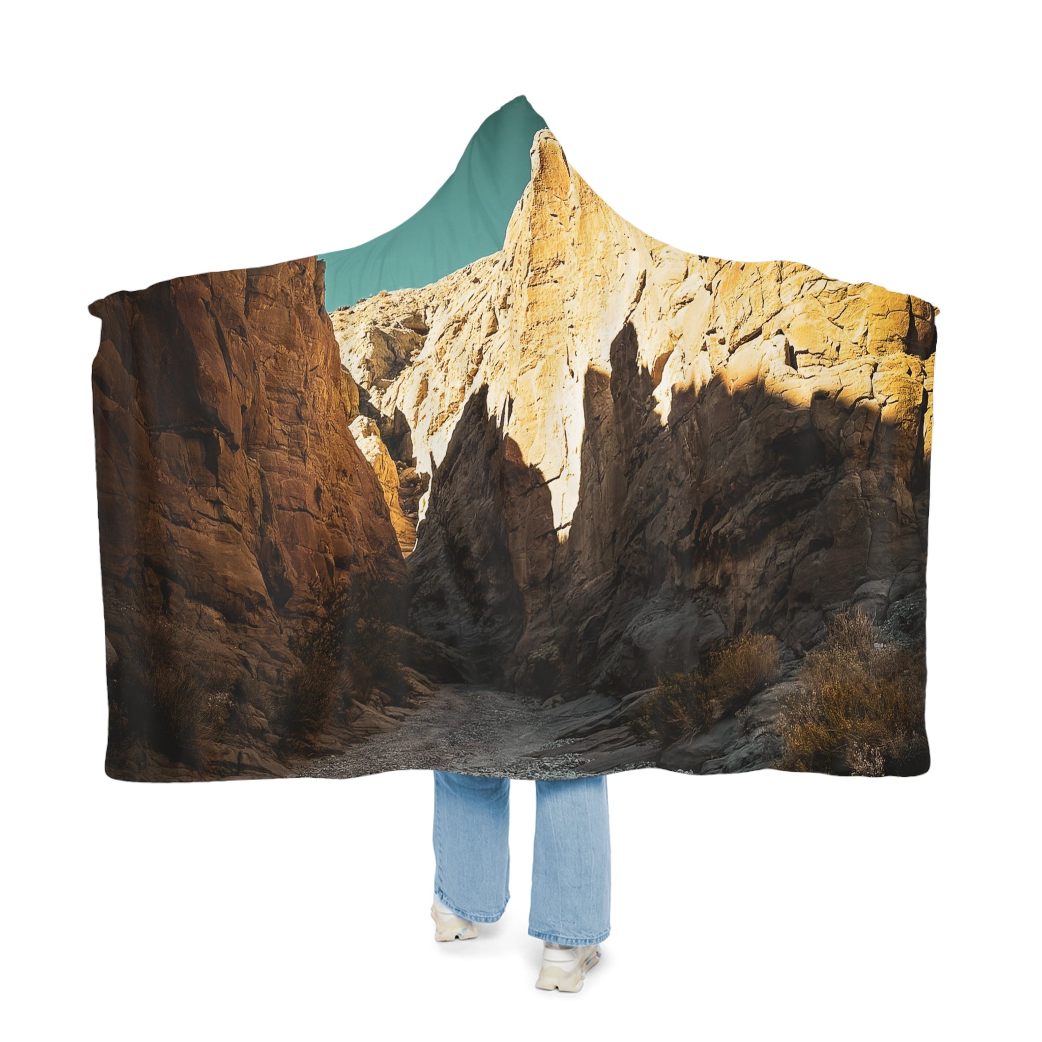 Person wearing a hoodie with a Sand Stone mountain landscape design on a white background