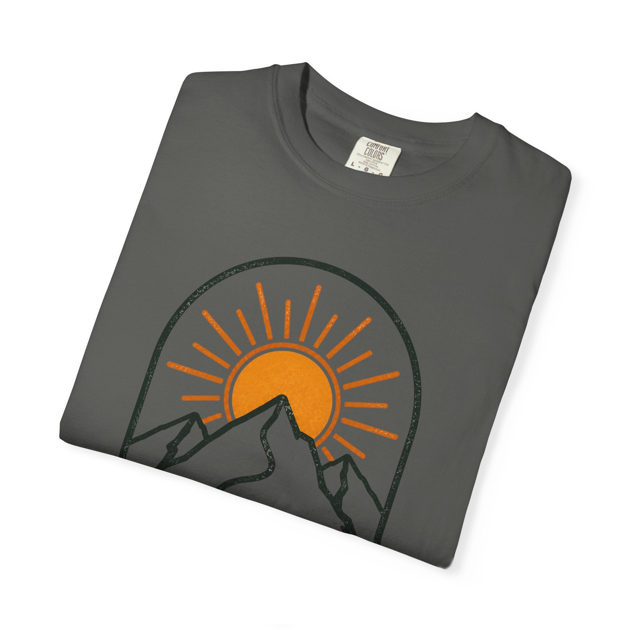 Folded gray t-shirt with a mountain and sun graphic on a white background