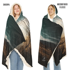 Two people wearing a large hooded blanket with a landscape design, labeled 'Sherpa' and 'Microfiber Fleece'.