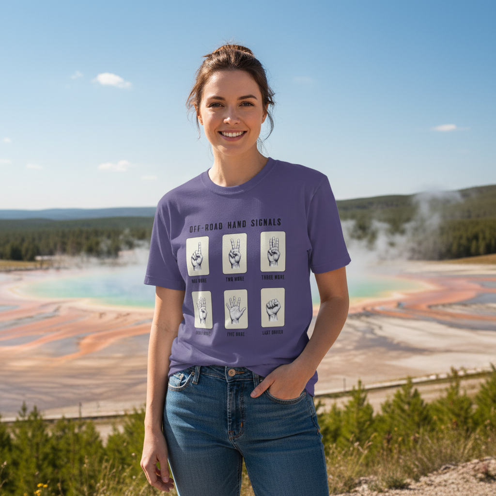 Woman wearing a purple t-shirt with hand signals in front of a scenic outdoor background