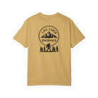 Mustard t-shirt  with a graphic design on the back featuring mountains, trees, and a silhouette of a Sasquatch