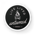 A magnet round bottle opener with 'Life Lived Untamed' text and campfire graphic 