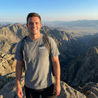 Man standing on a mountain peak with scenic view