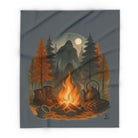 Blanket offers illustration of a campfire with a teapot, mug, and boots in a forest with a moonlit sky.