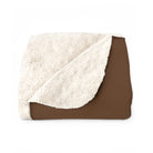 Brown and white sherpa blanket on a white background