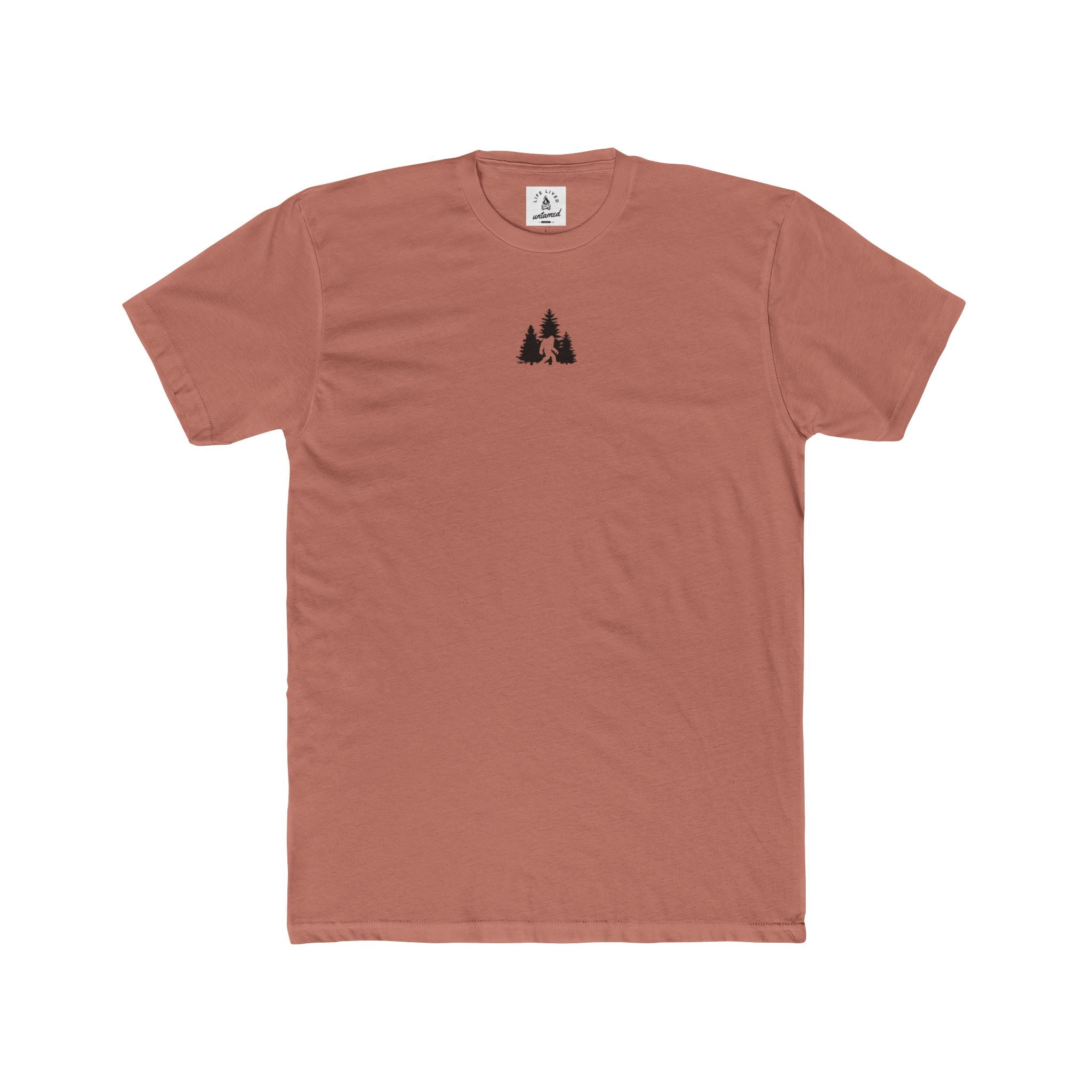 Solid_desert_pink t-shirt with a small Sasquatch in wilderness graphic on the chest against a white background