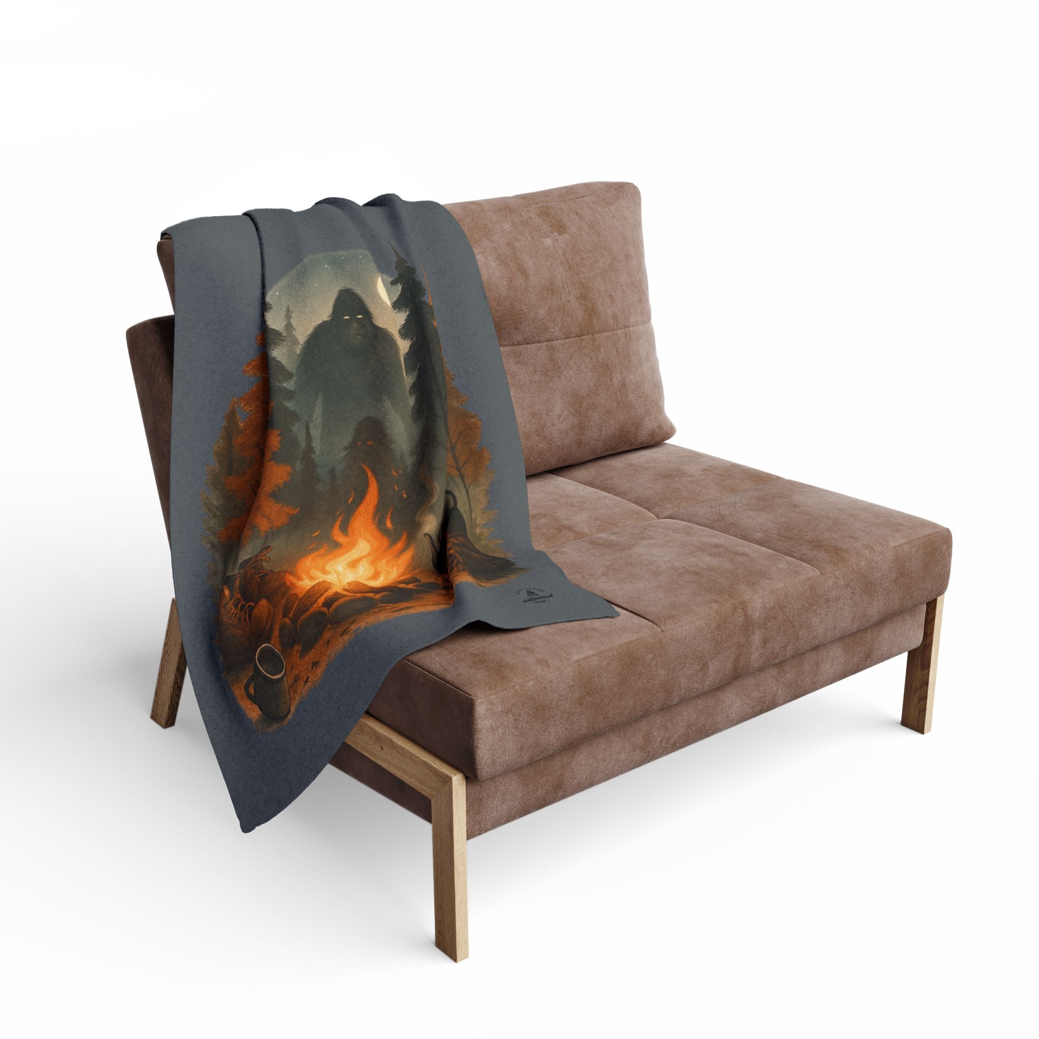 Blanket with a fiery design draped over a brown sofa on a white background
