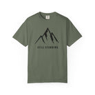 Moss green t-shirt with a mountain graphic and 'STILL STANDING' text on a white background