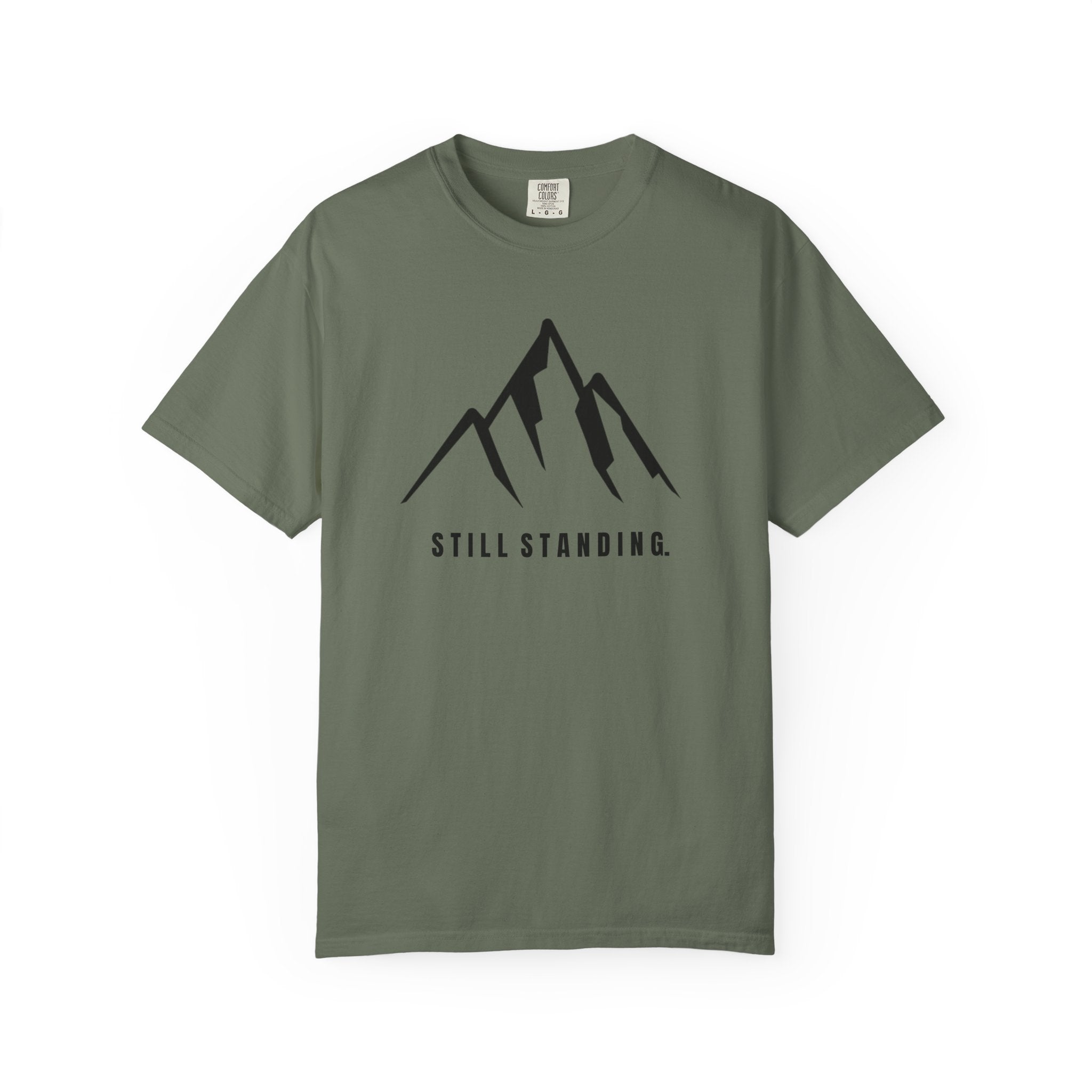 Moss green t-shirt with a mountain graphic and 'STILL STANDING' text on a white background