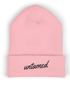 Pink beanie with 'untamed' text on a white background