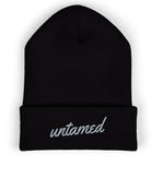Black beanie with 'untamed' embroidery on a white background