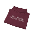 A  folded maroon hoodie with white mountain, desert and wave graphics on a white background.