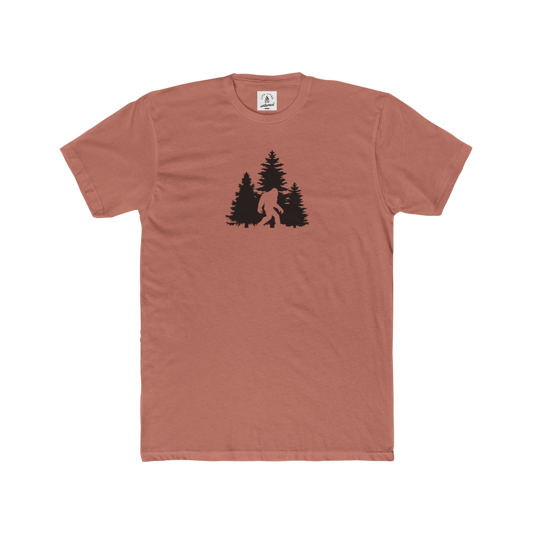 Brown t-shirt with a black graphic of a bigfoot and trees on a white background