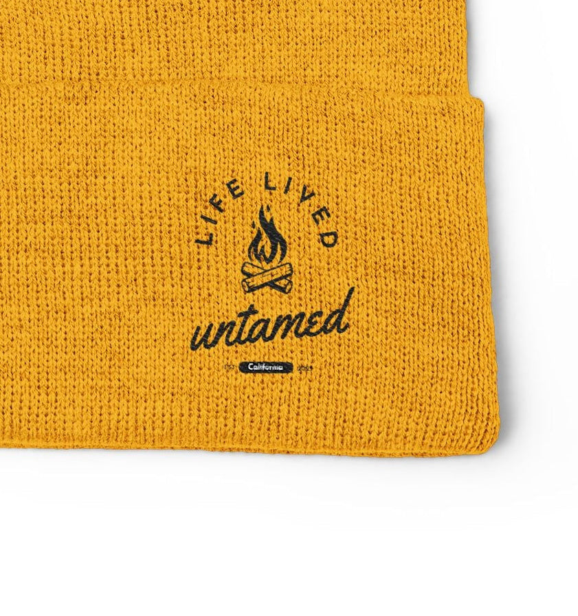 Yellow beanie with 'Life Lived Untamed' logo on a white background